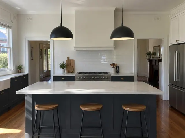 Two black pendant lights over a kitchen island in a modern home with white cabinets in Jesmond